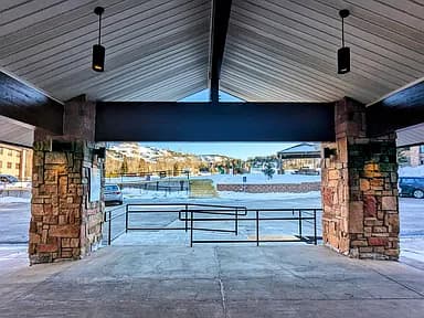 Covered stone entrance at the lodge with snowy mountains beyond